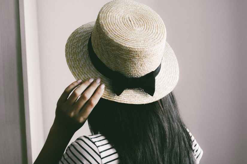person holding brown straw hat